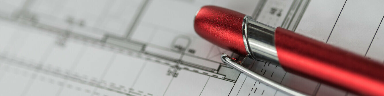 Red PREFA ballpoint pen on a plan