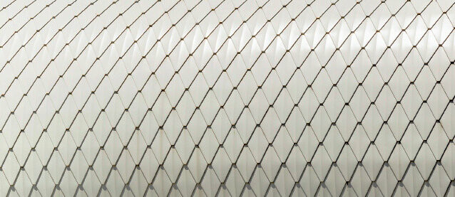 Detailed view of PREFA’s small rhomboid tile in pure white on rounded façade