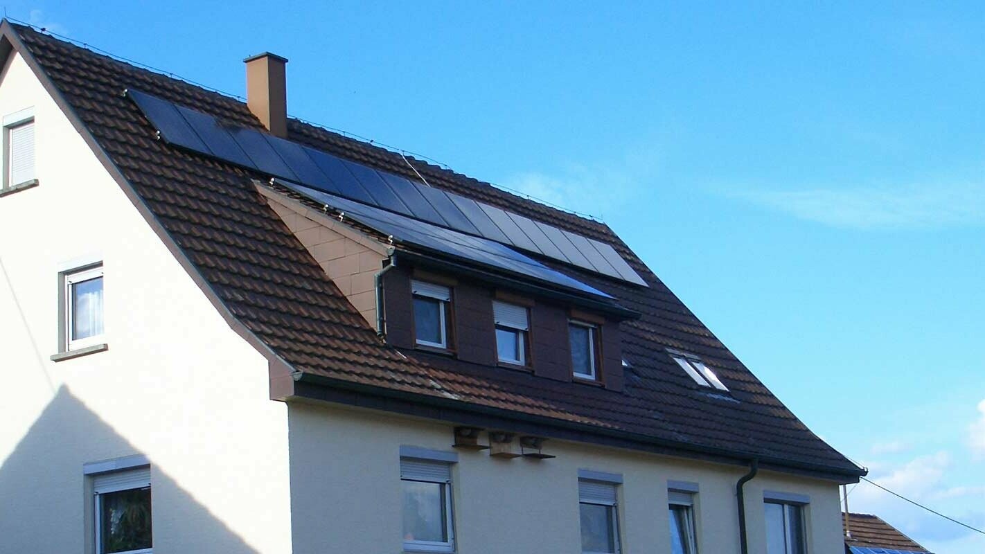 Detached house with a tiled roof in need of renovation; the roof has a dormer and a photovoltaic system.
