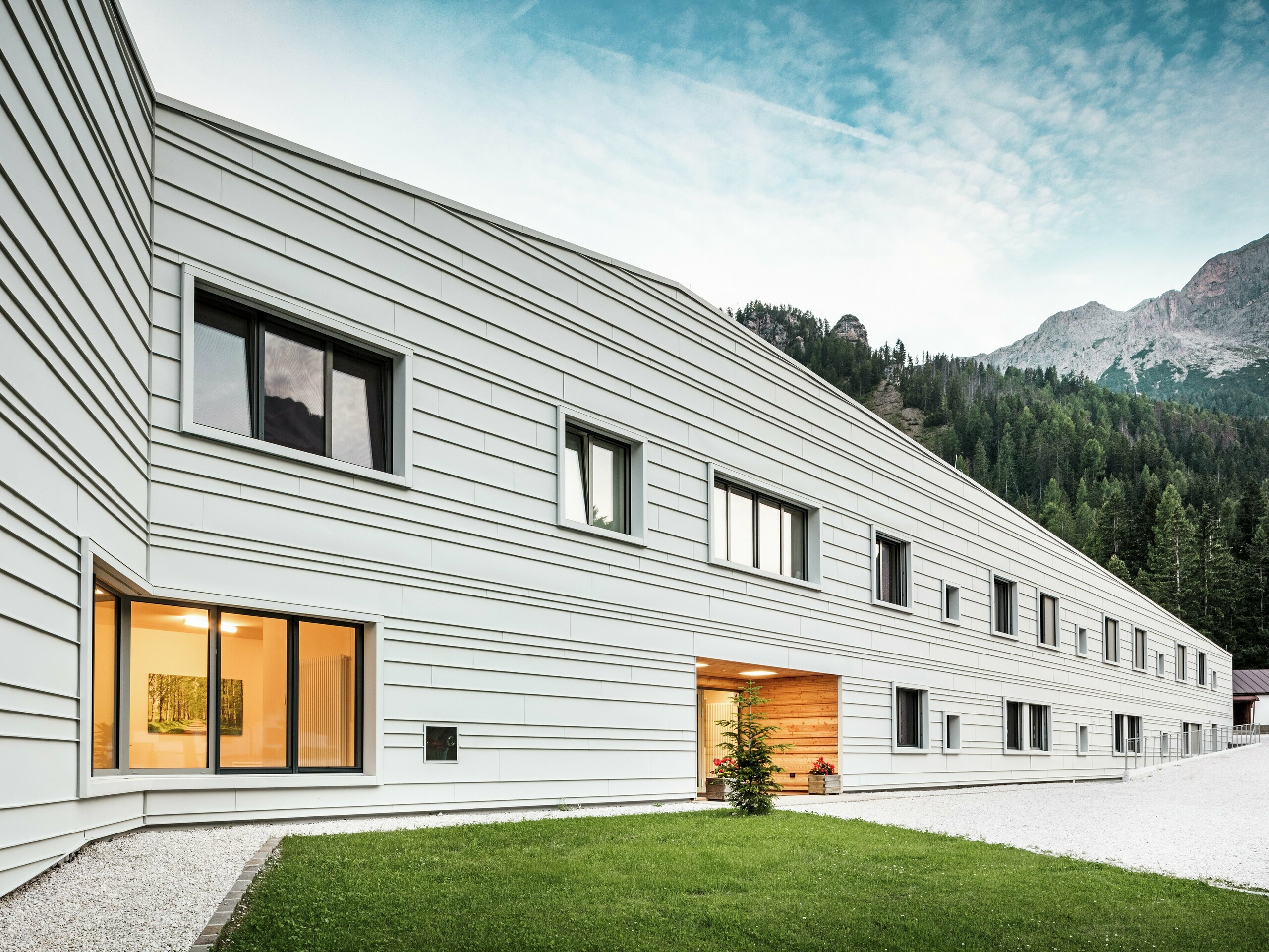 The modern Tempesti barracks in South Tyrol impresses with its clear façade design made of PREFALZ P.10 in PREFA white. The horizontal aluminium panels, laid at irregular intervals, make the building appear longer. The light aluminium façade reflects sunlight and thus ensures an improved microclimate. The modern barracks are an architectural statement in the midst of alpine nature.