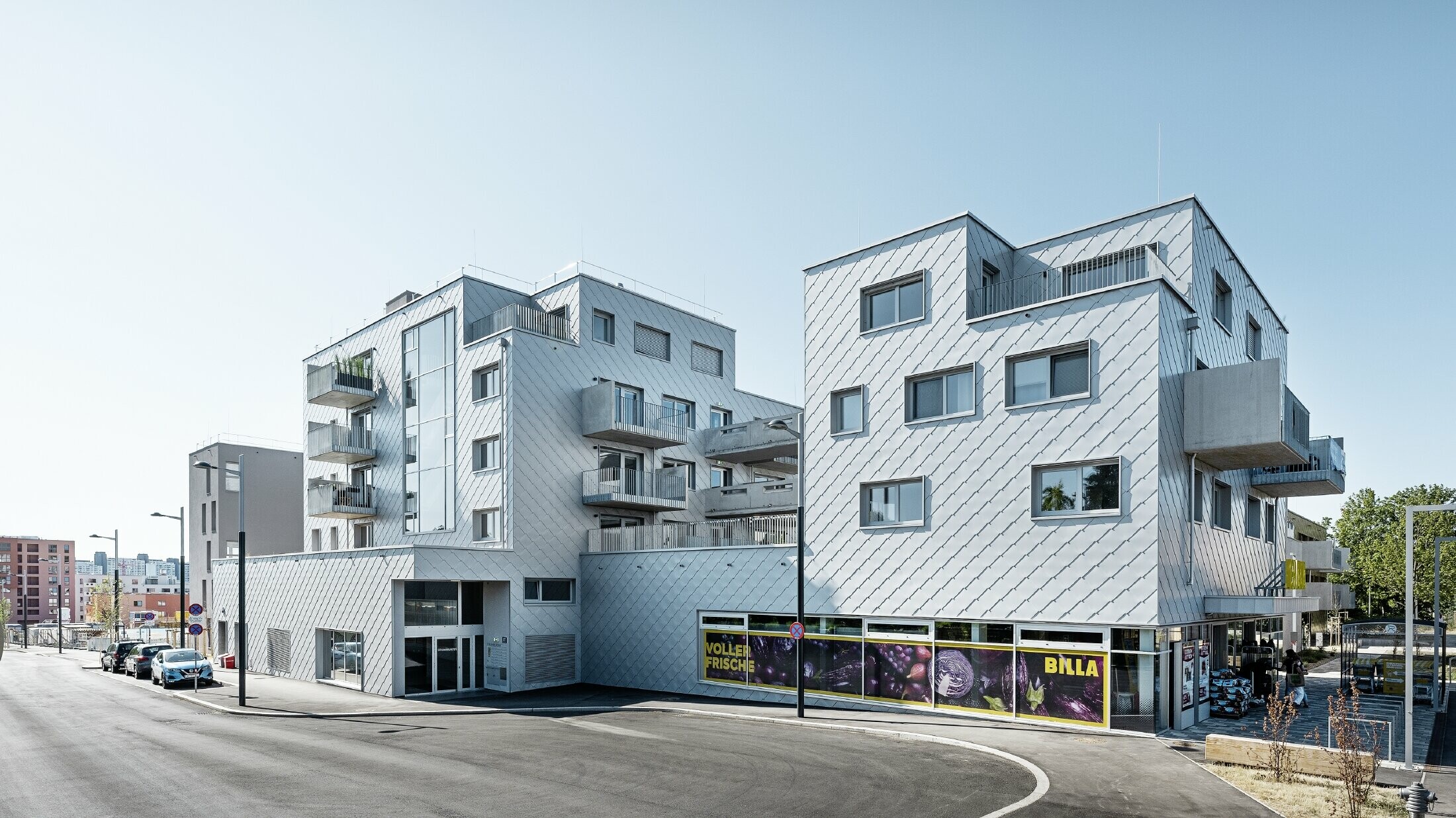 Apartment complexes with flat roof and rhomboid cladding on the façade with PREFA 44 × 44 rhomboid façade tiles in metallic silver