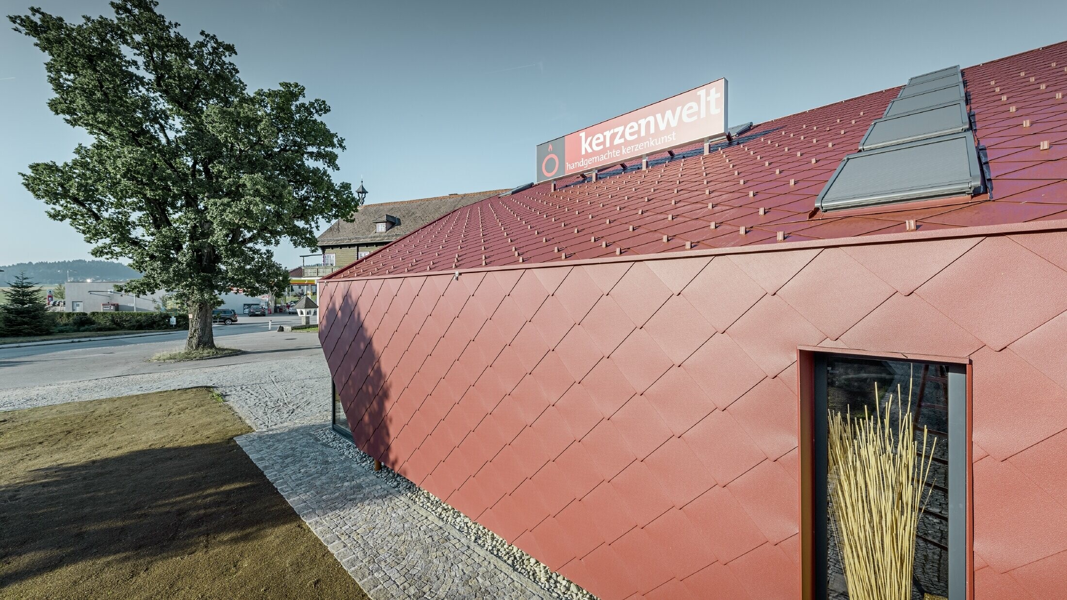 The Kerzenwelt candle store in Schlägl was completely reclad in the PREFA rhomboid tile. The 44 × 44 rhomboid façade tile in oxide red was used for the roof cover and the façade cladding.